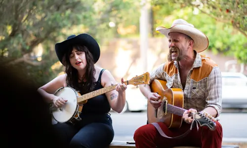 Two musicians playing a guitar and banjo at Young Henrys