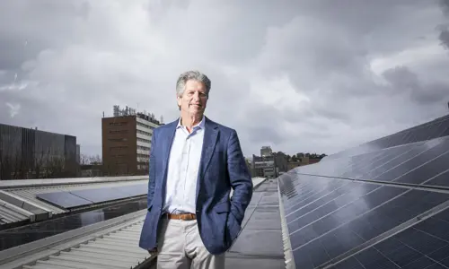 Profile photo of Professor Martin Green amongst a rooftop of solar panels