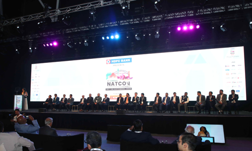 Panel of guests seated on stage during a presentation at the Credai Natcon event